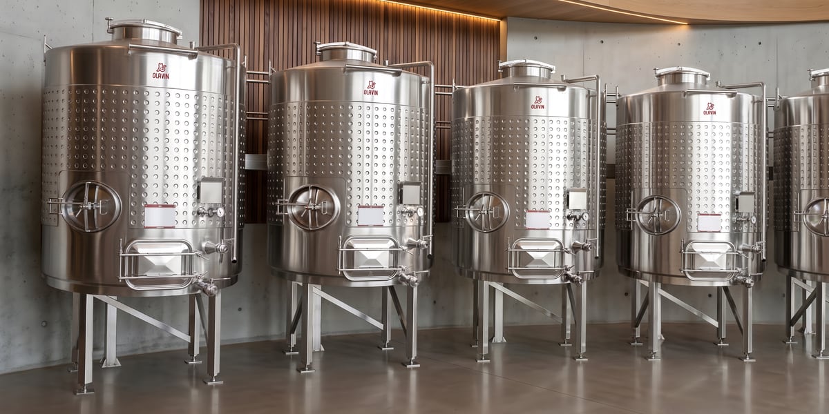 A row of five Olavin enclosed fermenters in a concrete and timber winery hall