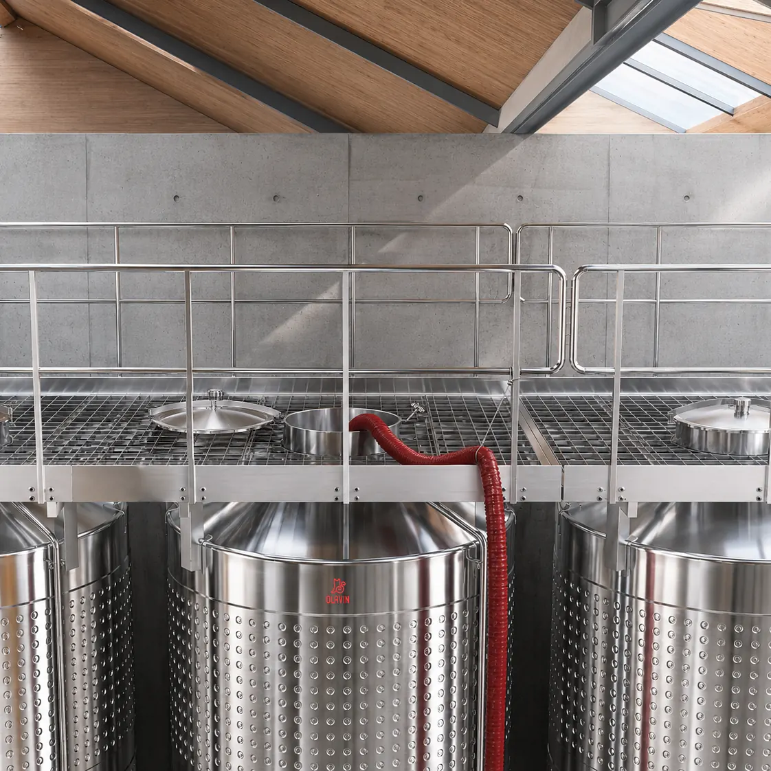 Crushed red must being pumped into an enclosed fermenter through the top entry after destemming and crushing